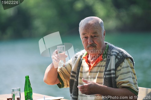 Image of senior man eat desser at outdoor restaurant