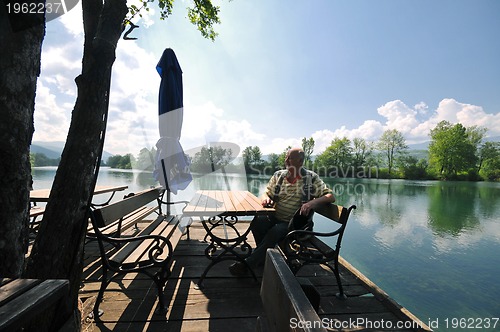 Image of senior man eat desser at outdoor restaurant