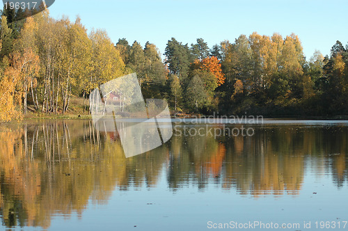 Image of Cabin by lake in autumn colors