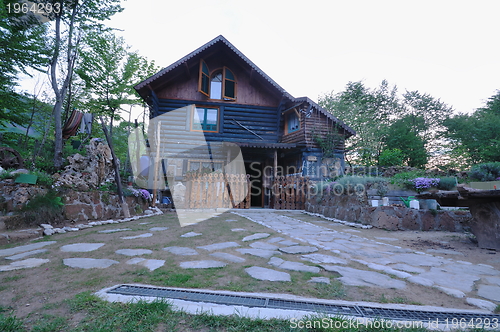 Image of wooden country house with beutiful garden