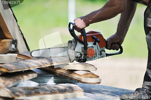 Image of wood worker with chainshaw closeup