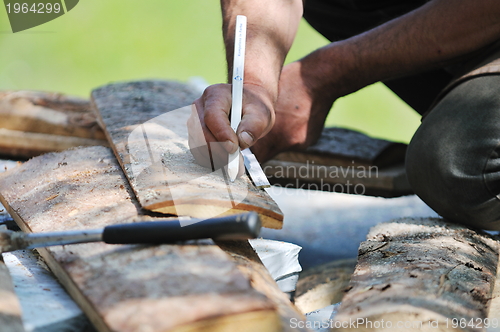 Image of wood worker with chainshaw closeup