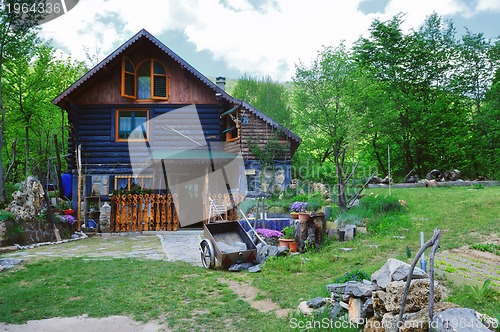 Image of wooden country house with beutiful garden