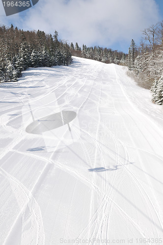 Image of tracks on ski slopes at beautiful sunny  winter day