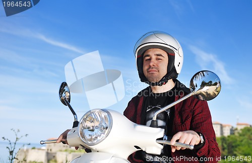 Image of young man ride retro scooter