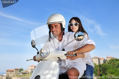 Image of Portrait of happy young love couple on scooter enjoying summer t