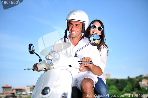 Image of Portrait of happy young love couple on scooter enjoying summer t