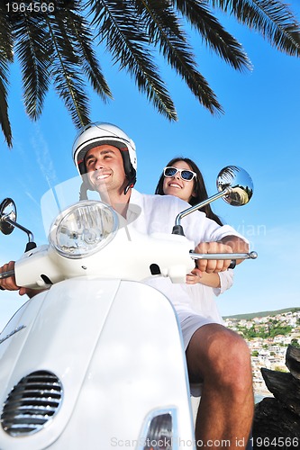 Image of Portrait of happy young love couple on scooter enjoying summer t