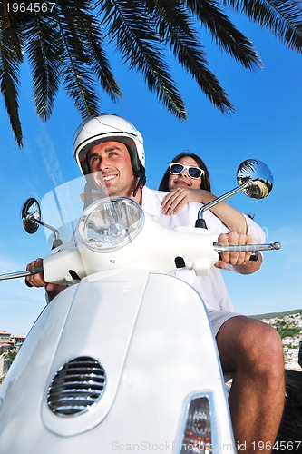 Image of Portrait of happy young love couple on scooter enjoying summer t