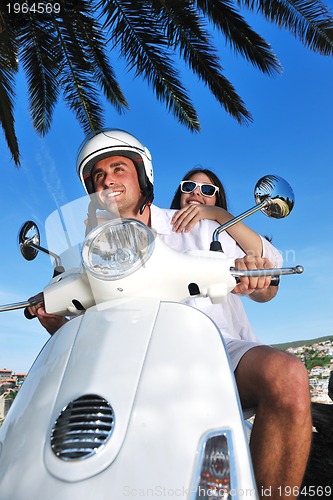 Image of Portrait of happy young love couple on scooter enjoying summer t