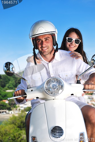 Image of Portrait of happy young love couple on scooter enjoying summer t