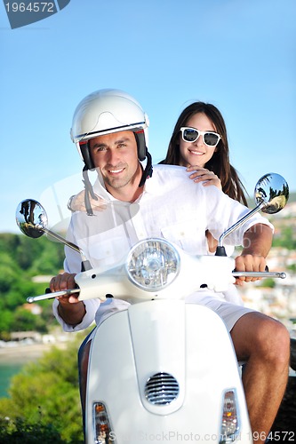 Image of Portrait of happy young love couple on scooter enjoying summer t