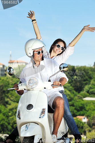 Image of Portrait of happy young love couple on scooter enjoying summer t