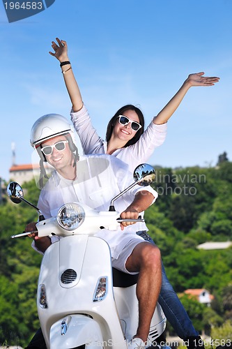 Image of Portrait of happy young love couple on scooter enjoying summer t