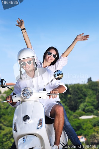 Image of Portrait of happy young love couple on scooter enjoying summer t