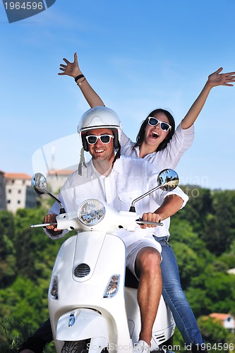 Image of Portrait of happy young love couple on scooter enjoying summer t