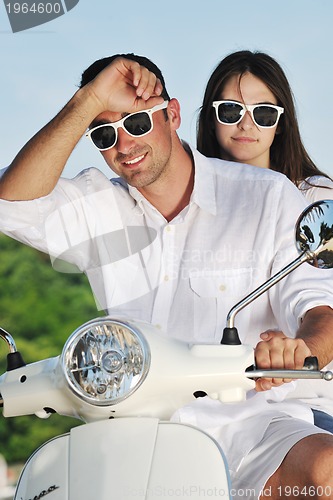 Image of Portrait of happy young love couple on scooter enjoying summer t