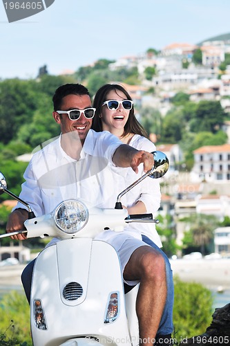 Image of Portrait of happy young love couple on scooter enjoying summer t