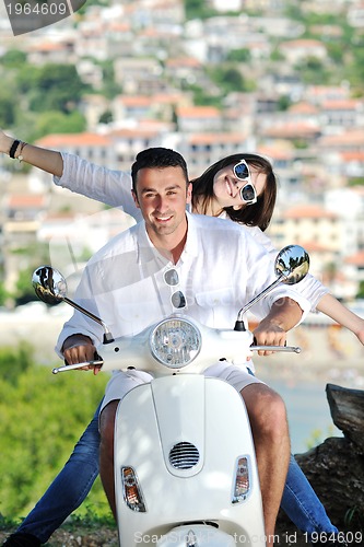 Image of Portrait of happy young love couple on scooter enjoying summer t