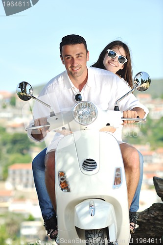 Image of Portrait of happy young love couple on scooter enjoying summer t