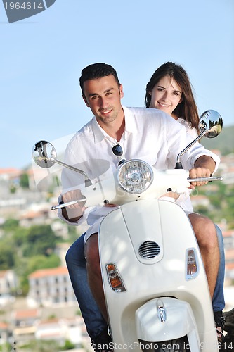 Image of Portrait of happy young love couple on scooter enjoying summer t