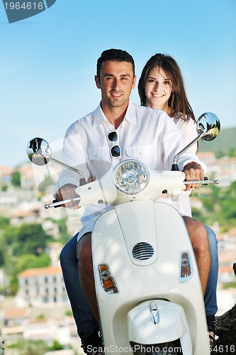 Image of Portrait of happy young love couple on scooter enjoying summer t