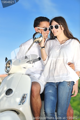 Image of Portrait of happy young love couple on scooter enjoying summer t