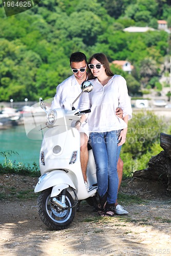 Image of Portrait of happy young love couple on scooter enjoying summer t