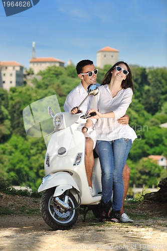 Image of Portrait of happy young love couple on scooter enjoying summer t