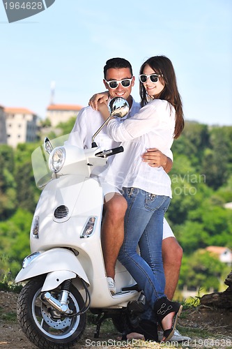 Image of Portrait of happy young love couple on scooter enjoying summer t