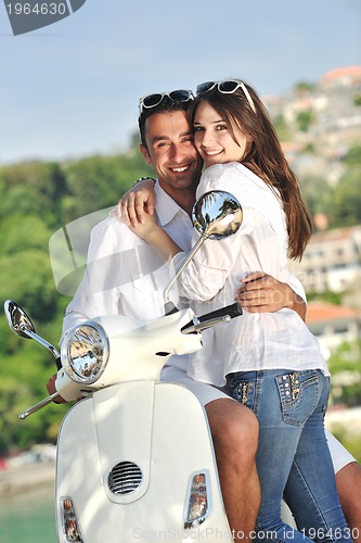 Image of Portrait of happy young love couple on scooter enjoying summer t