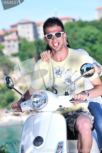 Image of Portrait of happy young love couple on scooter enjoying summer t