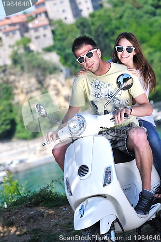 Image of Portrait of happy young love couple on scooter enjoying summer t