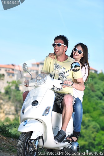 Image of Portrait of happy young love couple on scooter enjoying summer t