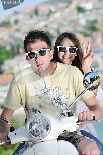 Image of Portrait of happy young love couple on scooter enjoying summer t