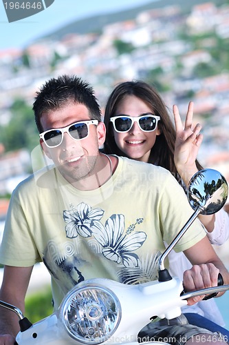 Image of Portrait of happy young love couple on scooter enjoying summer t