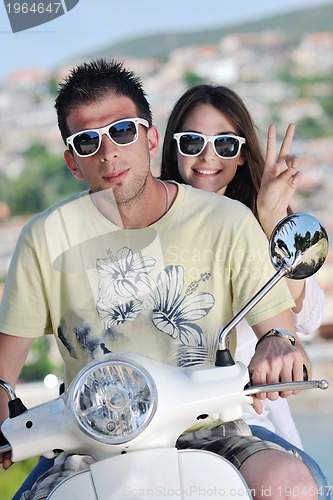 Image of Portrait of happy young love couple on scooter enjoying summer t