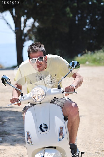 Image of Portrait of happy young love couple on scooter enjoying summer t