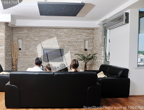 Image of family wathching flat tv at modern home indoor