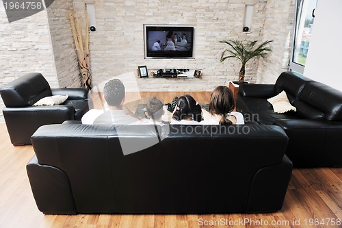 Image of family wathching flat tv at modern home indoor