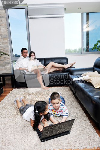 Image of happy young family have fun and working on laptop at home