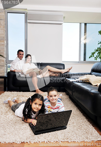 Image of happy young family have fun and working on laptop at home