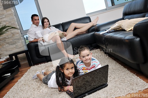 Image of happy young family have fun and working on laptop at home