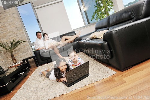 Image of happy young family have fun and working on laptop at home