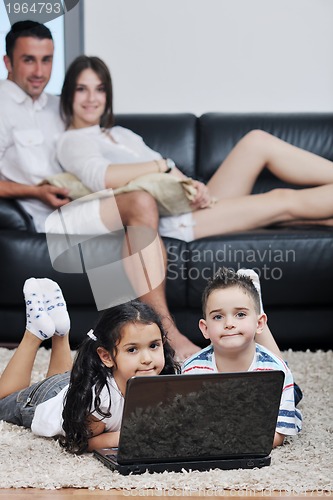 Image of happy young family have fun and working on laptop at home