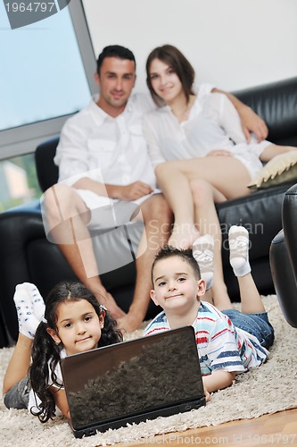 Image of happy young family have fun and working on laptop at home