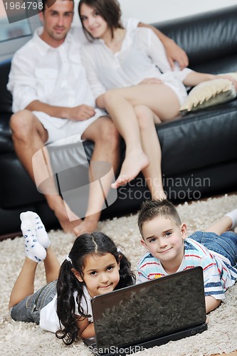 Image of happy young family have fun and working on laptop at home