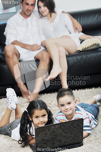 Image of happy young family have fun and working on laptop at home