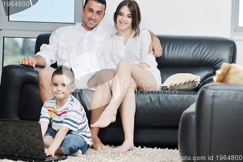 Image of happy young family have fun and working on laptop at home