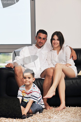 Image of happy young family have fun and working on laptop at home